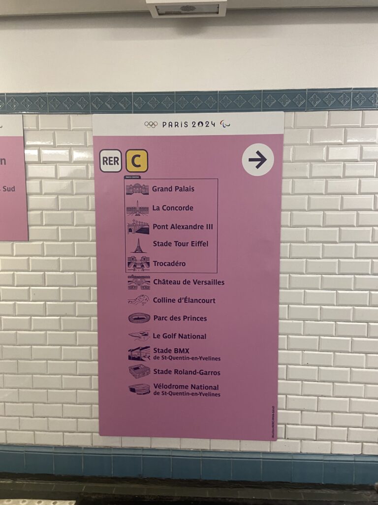 Image of pink wayfinding sign in Paris metro